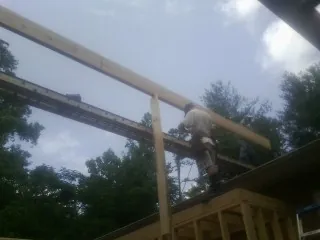Carpenter setting a ridge beam over a new addition frame — Ice Dam Removal by Roofing Brothers in Horse Creek