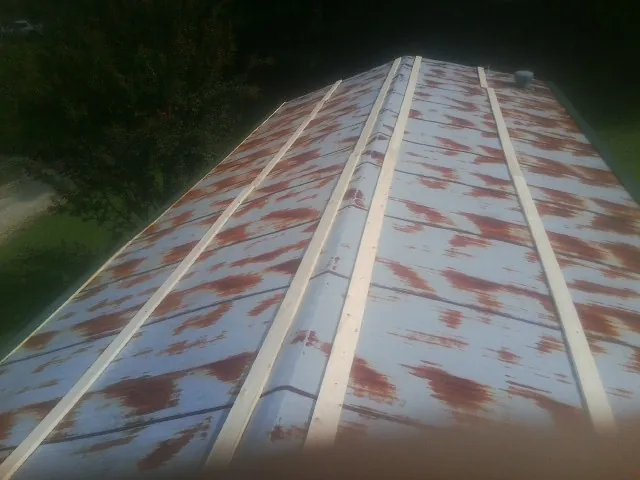 Rusted metal roof panels with new wood purlins before replacement — Storm Damage Roof Repair in Horse Creek by Roofing Brothers