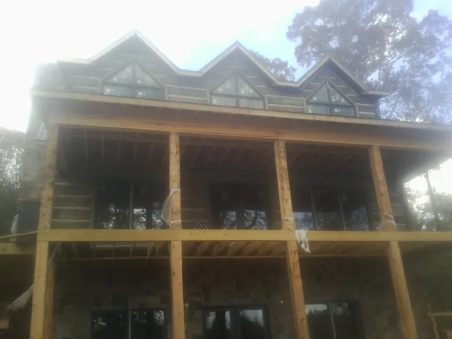 Dormers and porch framing on a large log home under construction — Roof Coating work by our crew in Horse Creek